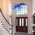 Foyer with a blue Chihuly chandelier, wooden door, and staircase.
