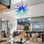 Modern living room with a Chihuly Blue Hand-Blown Glass Chandelier, sofa, coffee table, and chairs.
