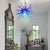 Celestial Blue Hand-Blown Glass Chandelier – Inspired by the Sea and Sky in a room with a mirror, table, and plants.