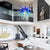 Modern living room with a blue Chihuly chandelier, white sofa, and staircase.