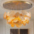 A stunning gold monstera leaf chandelier hangs from a polished ceiling plate.
